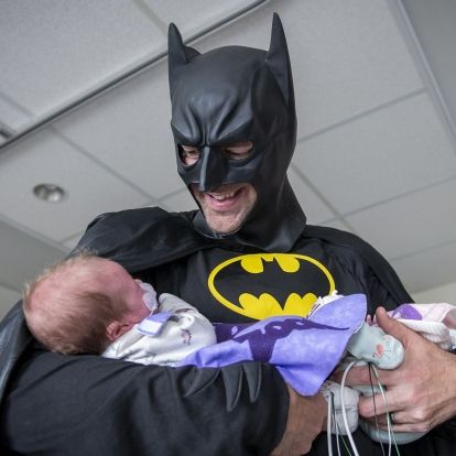 batman holding a baby