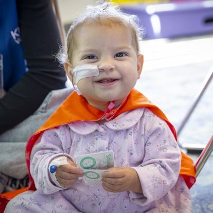 baby in an orange cape