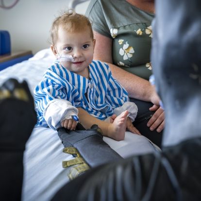 batman greets a smiling toddler at KHSC