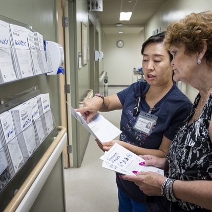A staff member provides a patient with literature on cancer care.