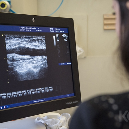 A healthcare practitioner using an ultrasound machine on a patients neck.