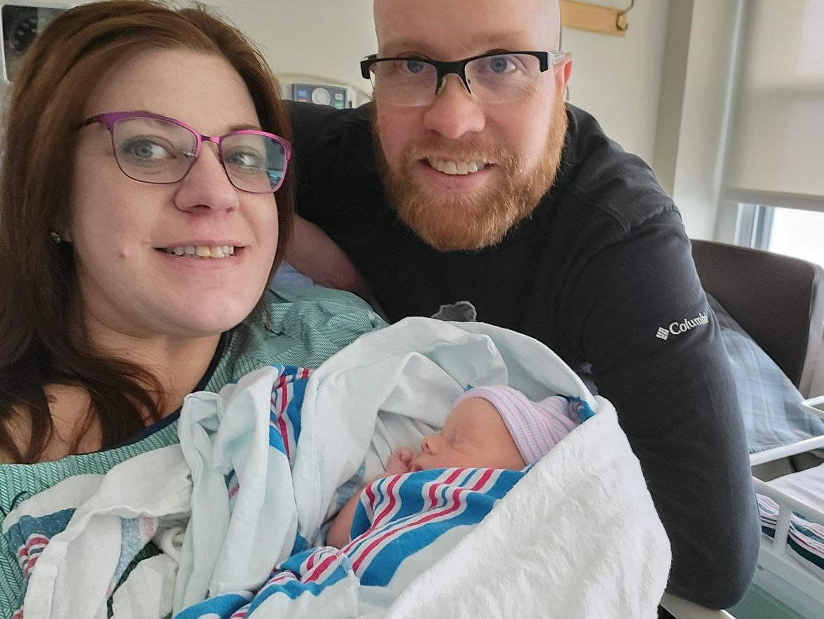 young couple holding newborn baby