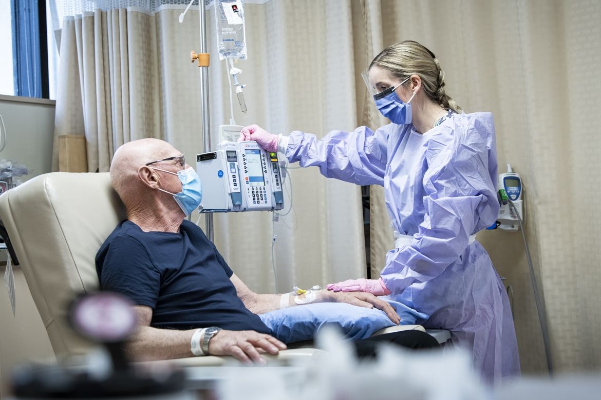 A patient with cancer speaks with an oncology nurse.