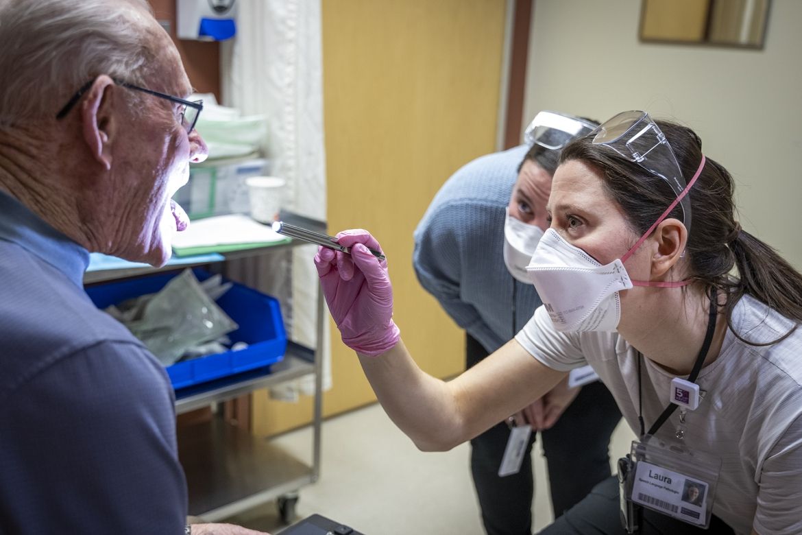 A speech language pathologist examines a patient