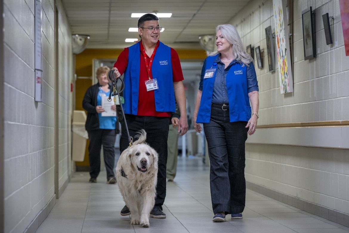 Therapy dog and volunteers walking through corridor at KGH.