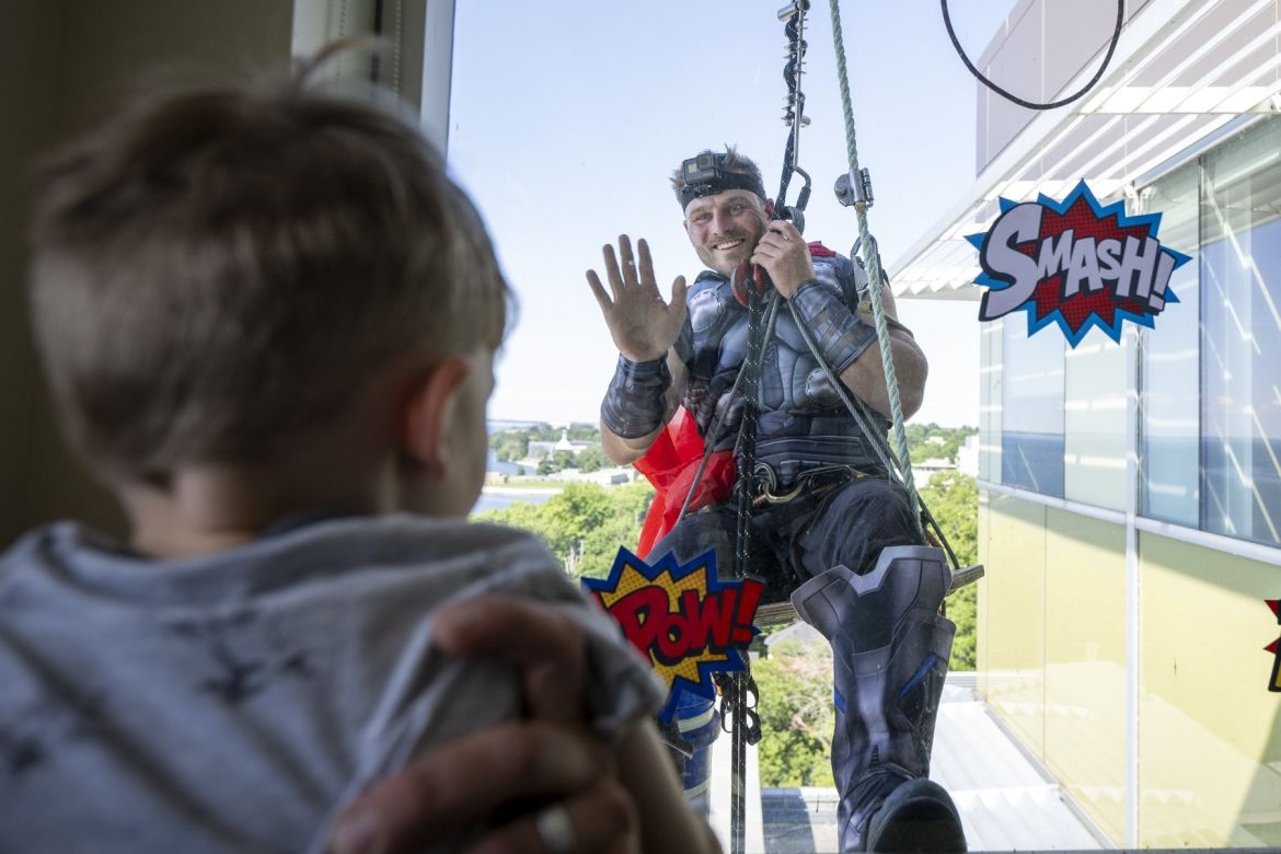 Captain America waves to a young patient at KHSC