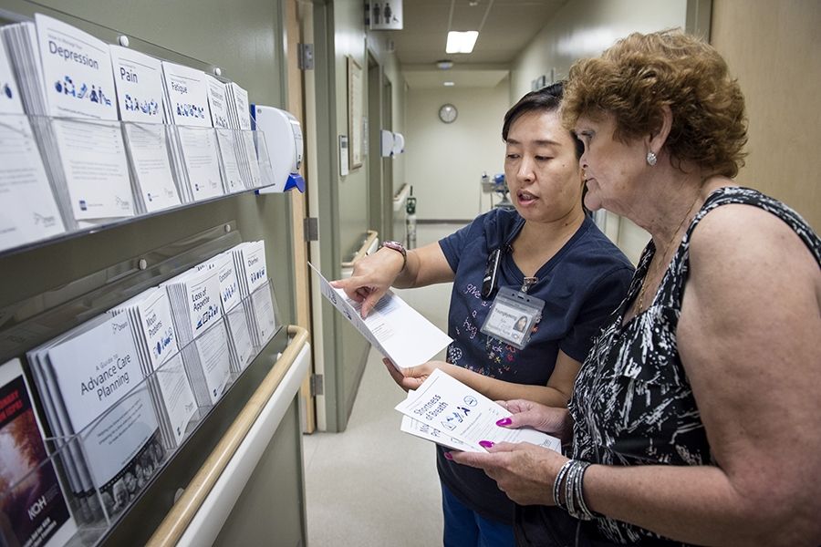 A staff member provides a patient with literature on cancer care.