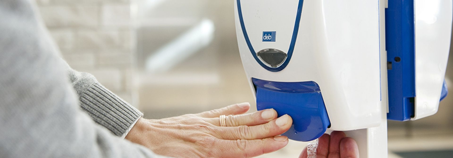 A person using a hand hygiene station at KGH.