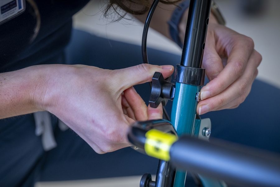 A close up shot of Justine White’s hands working on a walker, a mobility aid device. She’s tightening a screw.