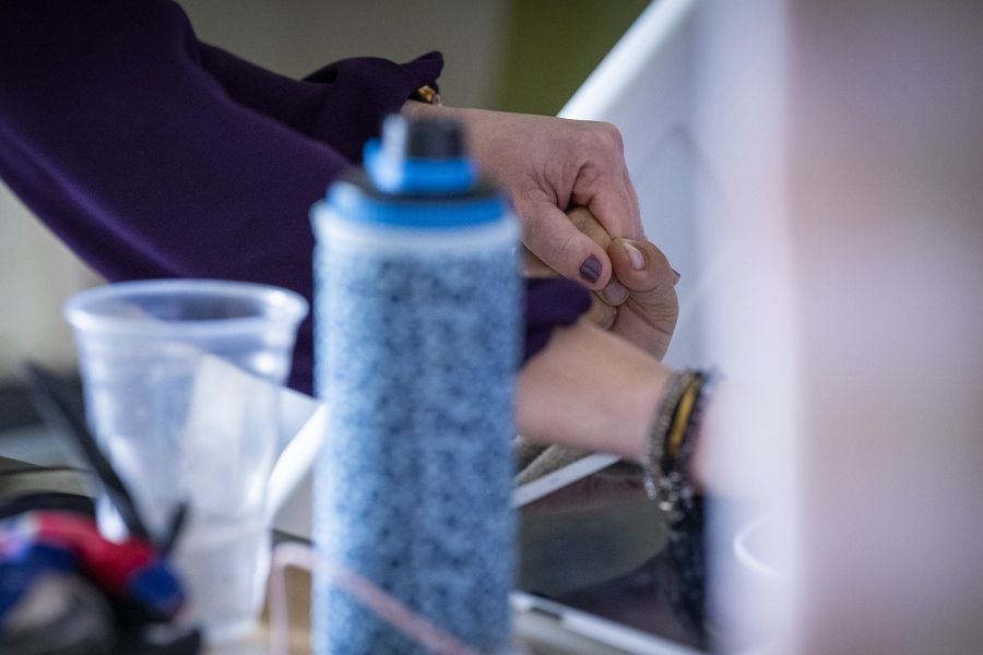 A close up shot of Melissa Meisner holding hands with a patient, who is being monitored in the EMU.