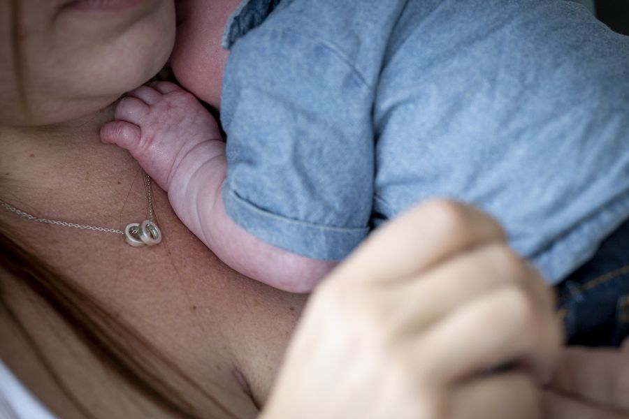 close up of a woman holding a baby on her chest