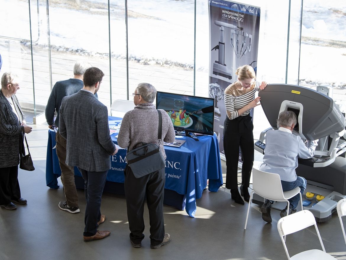 Attendees gathered around a presentation booth.