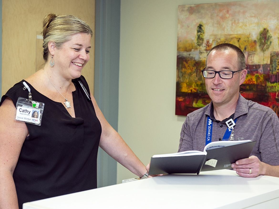 Dr. Boyd and Cathy MacGillivary talking at the care desk in the iCU