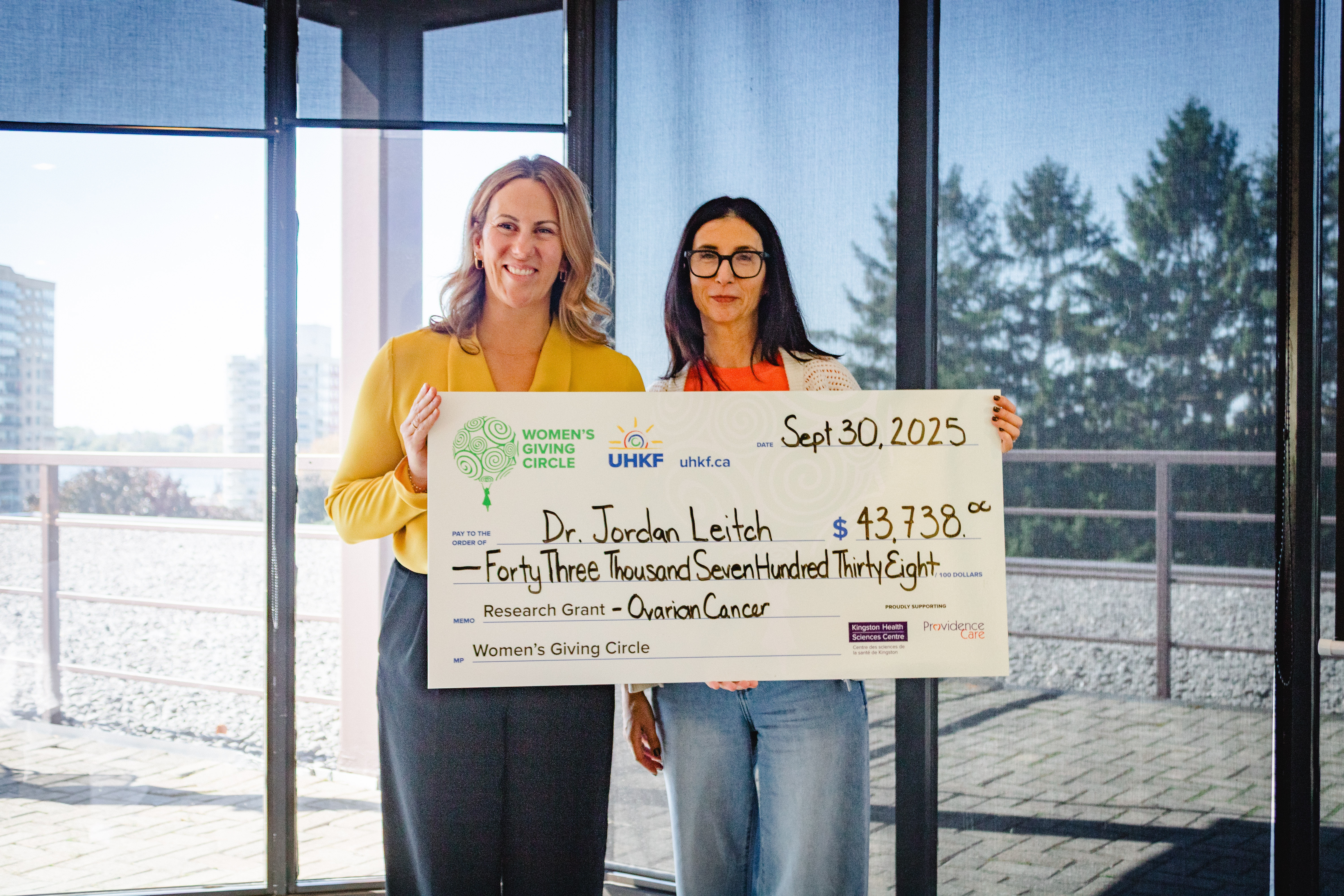 KHSC anesthesiologist Dr. Jordan Leitch (left) receives the donation from Rachel Koven, chair of the Women’s Giving Circle (right).
